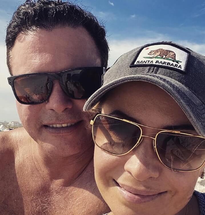 A man and a woman smiling outside.