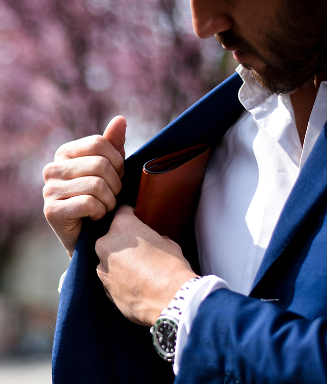 Man placing wallet in suit jacket pocket