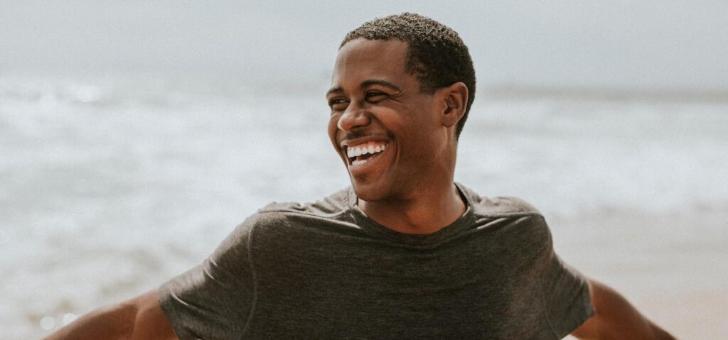 Man at the beach after a hair transplant.